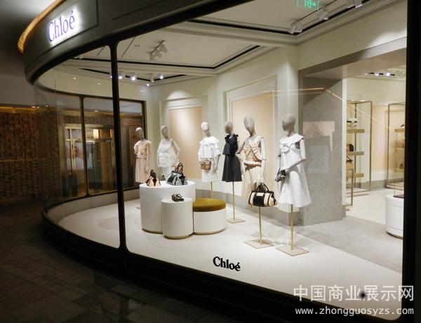 店面设计简约大气,店面内部是干净明快的白色,金色的不锈钢衣架尽显高